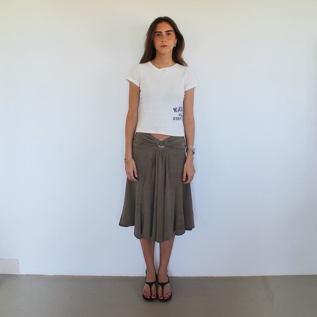 Model wearing a white wannabes* | Clothing Brand CASA DO SURF t-shirt with a brown midi skirt and black sandals